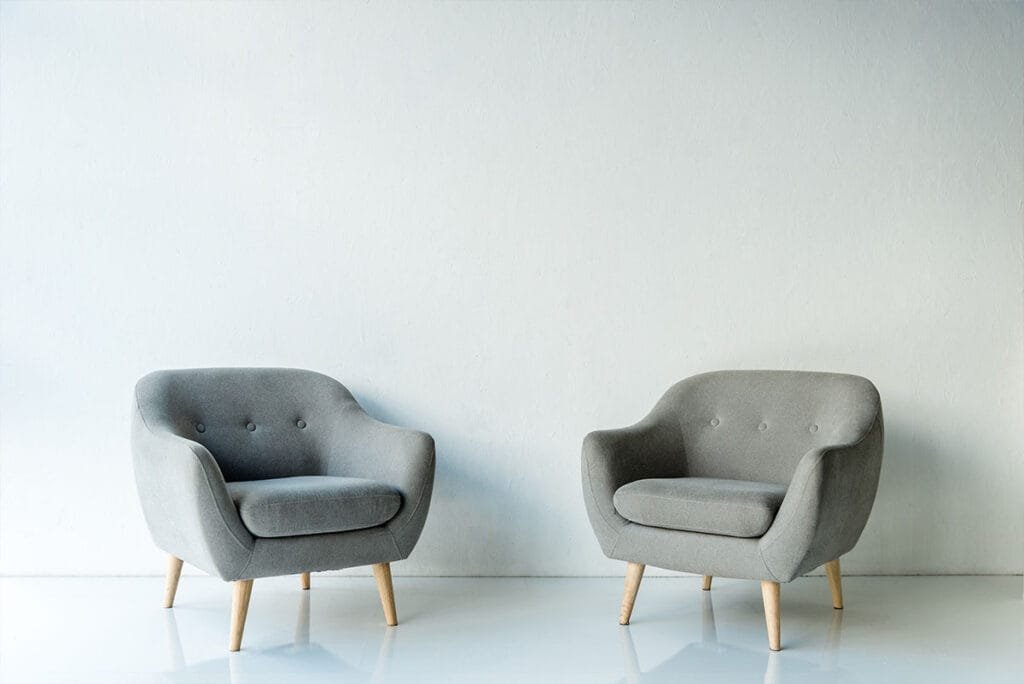 two-gray-armchairs-with-wooden-legs-in-a-room By RISHABH DESIGNS & INTERIOR